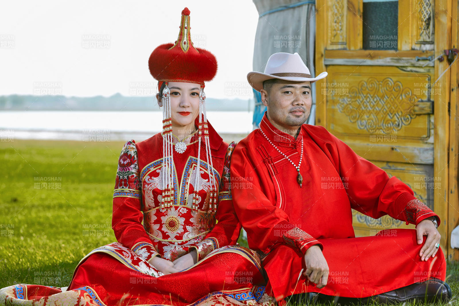 草原上蒙古包前穿蒙古族传统服饰的年轻夫妻图片