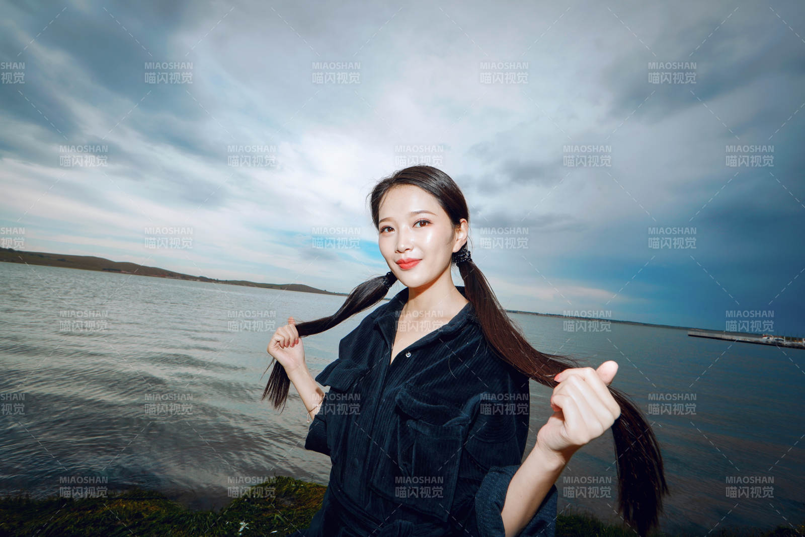 悠闲的坐在美丽湖岸码头的长发少女图片