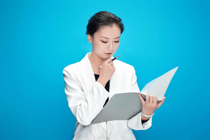 身穿西服拿着手机与文件夹的亚洲商务女士图片