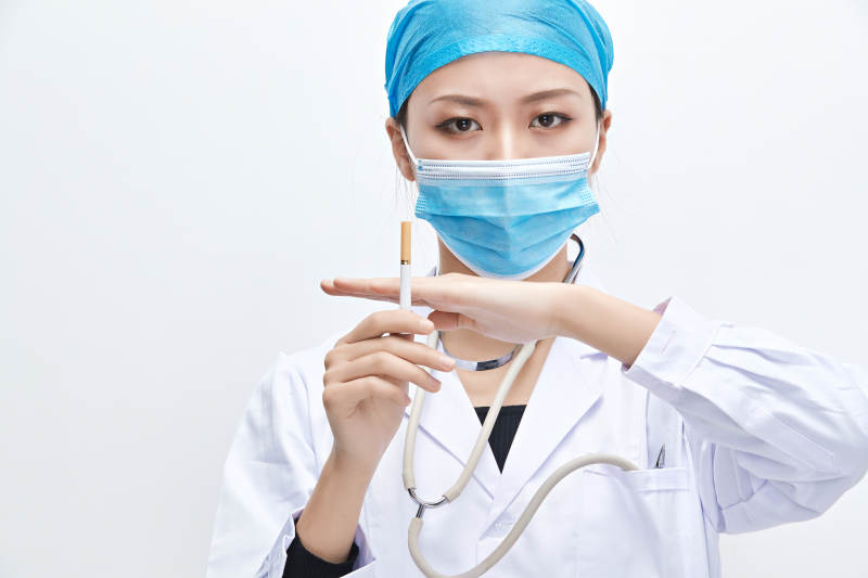 白色背景下传递传递吸烟有害健康信息的医生图片