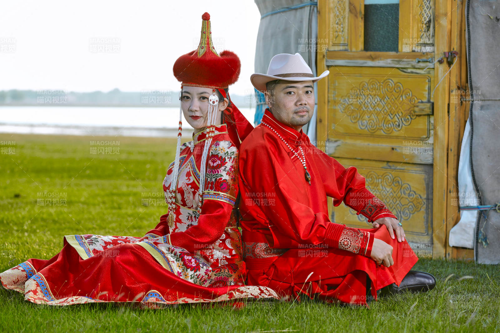 草原上蒙古包前穿蒙古族传统服饰的年轻夫妻图片