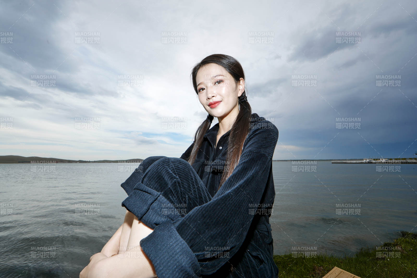 悠闲的坐在美丽湖岸码头的长发少女图片