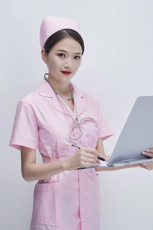 穿粉色护士服戴听诊器手持病历夹的医护人员图片