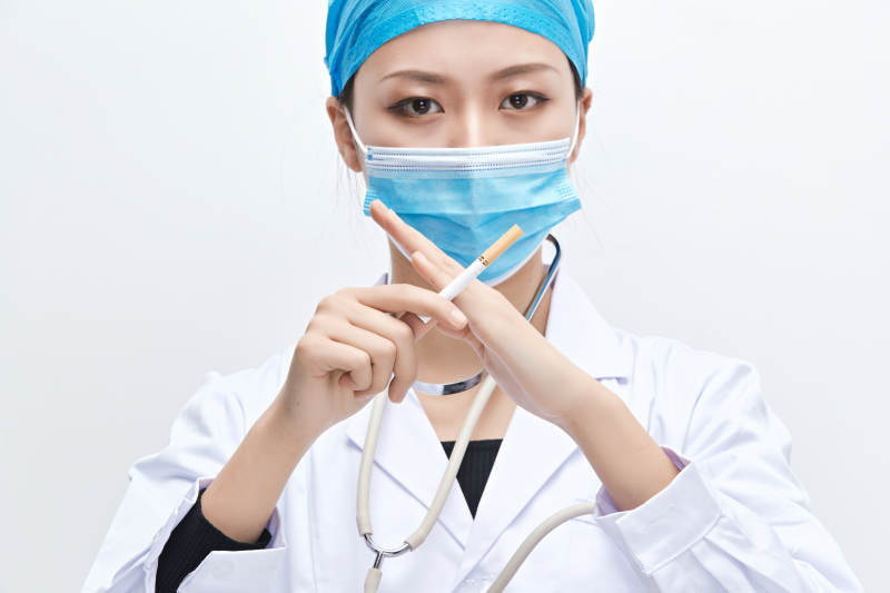 白色背景下传递传递吸烟有害健康信息的医生图片