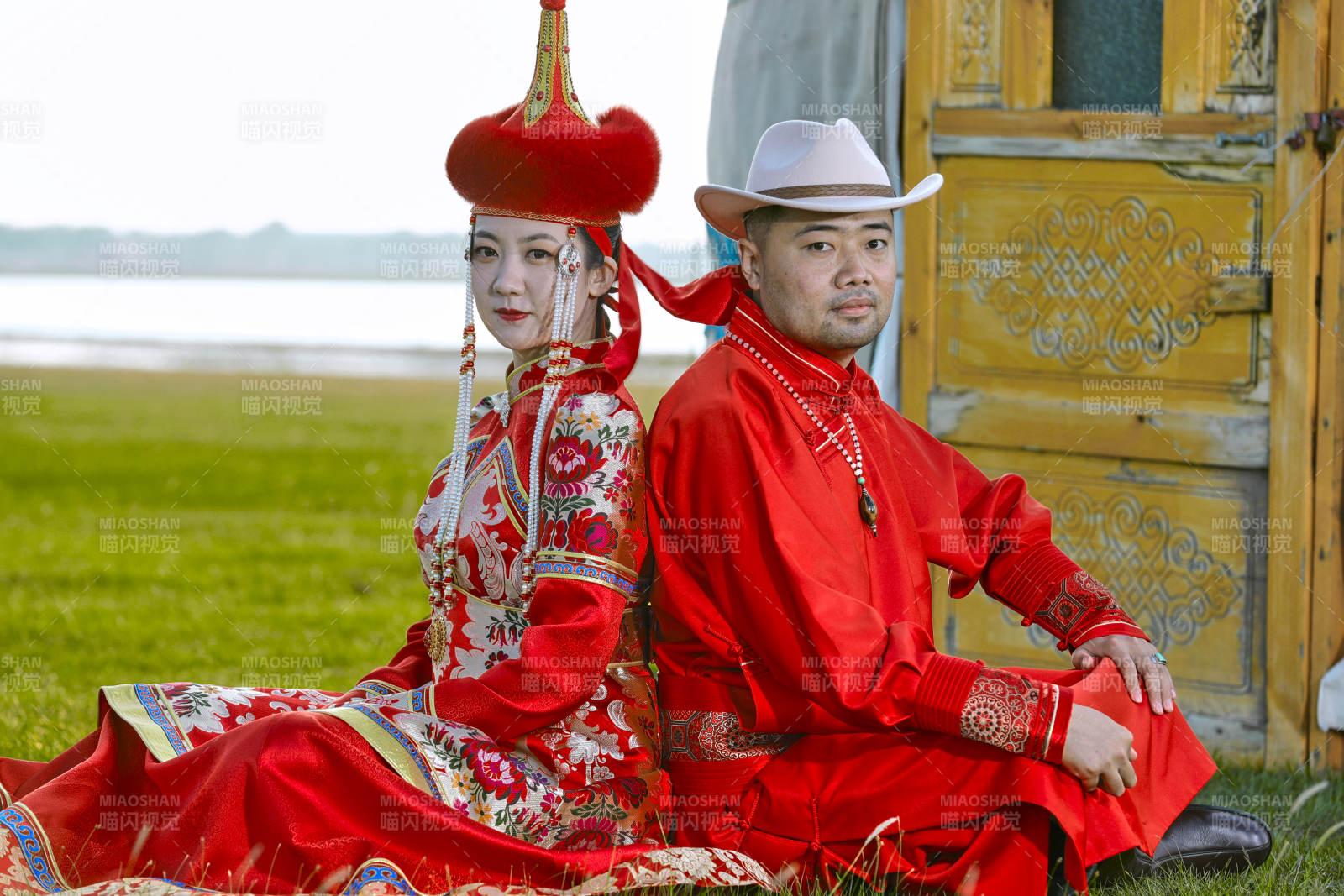 草原上蒙古包前穿蒙古族传统服饰的年轻夫妻图片