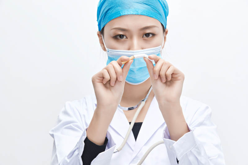 白色背景下传递传递吸烟有害健康信息的医生图片