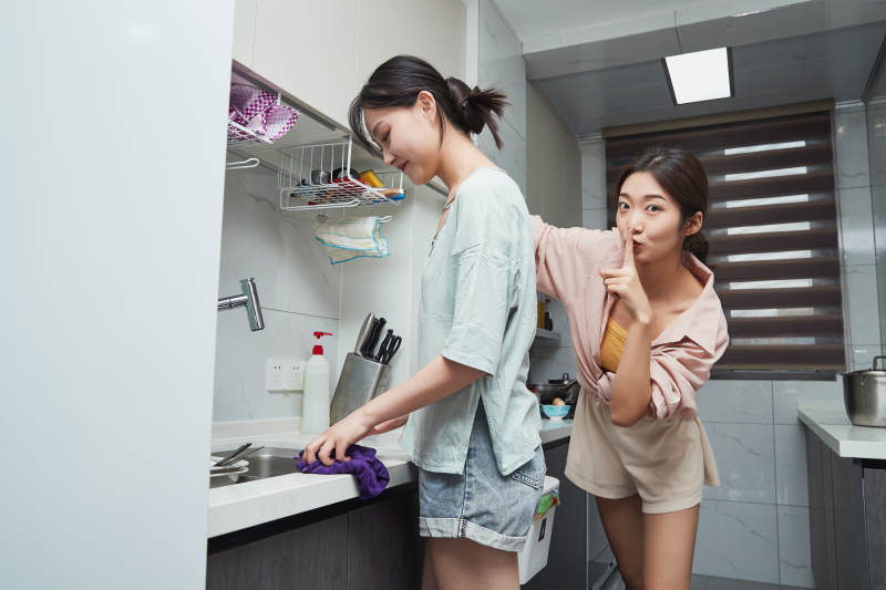 在厨房烹饪美食的亚洲闺蜜少女图片