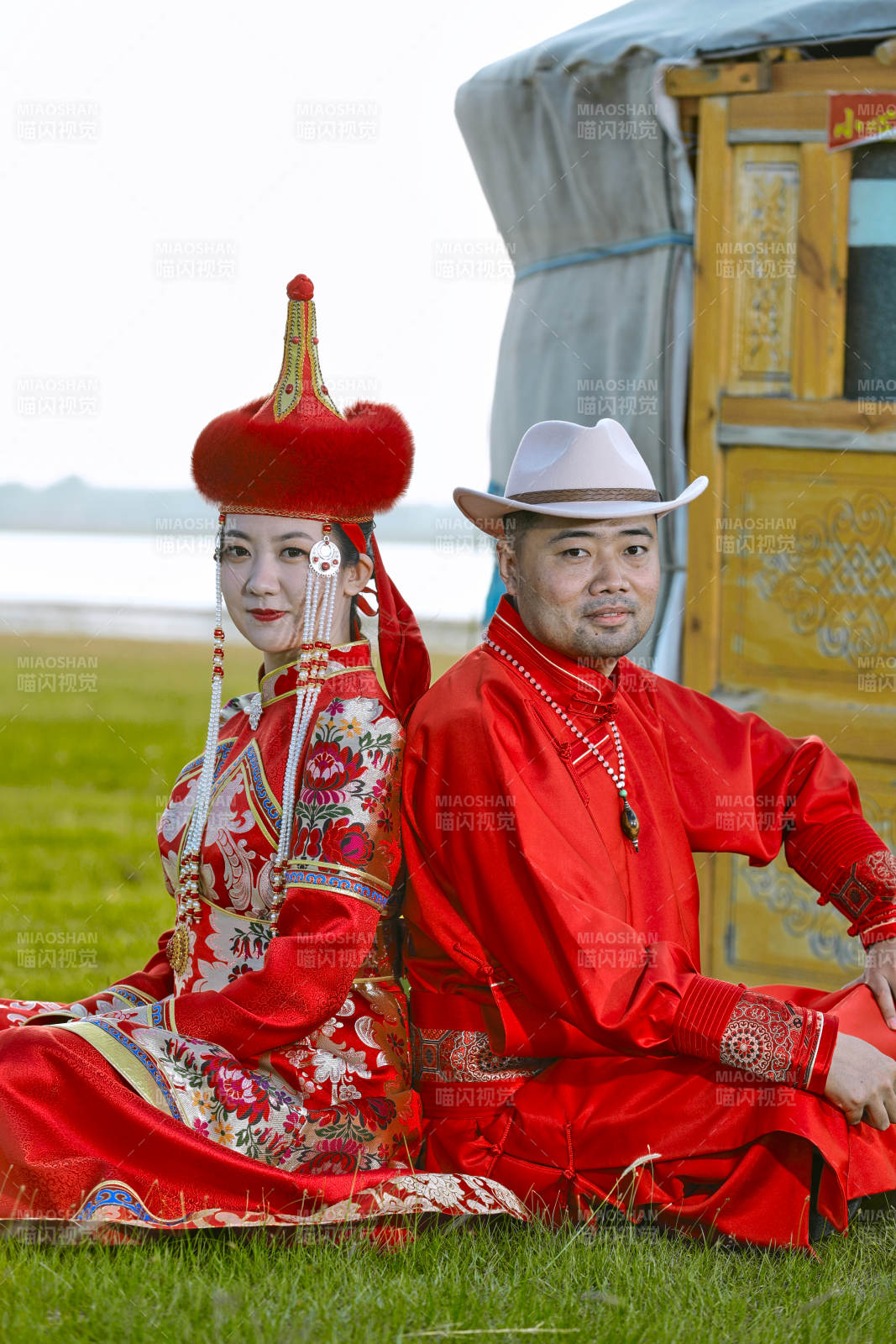 草原上蒙古包前穿蒙古族传统服饰的年轻夫妻图片