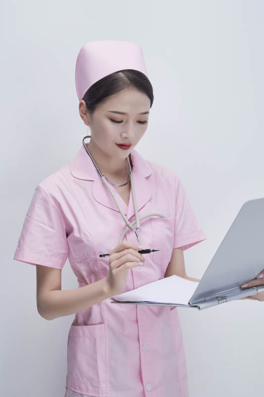 穿粉色护士服戴听诊器手持病历夹的医护人员图片