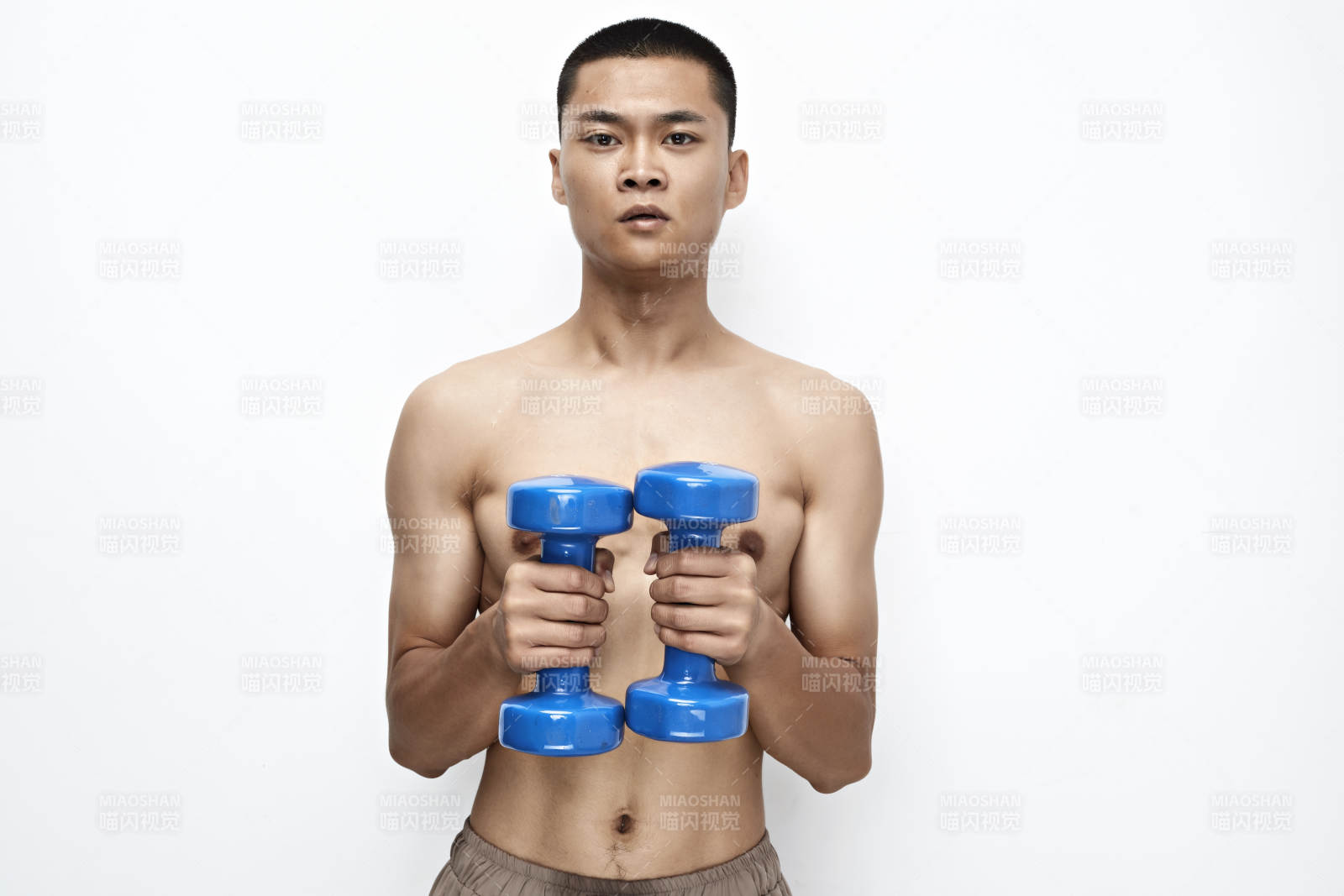 使用哑铃进行健身锻炼的亚洲男性图片