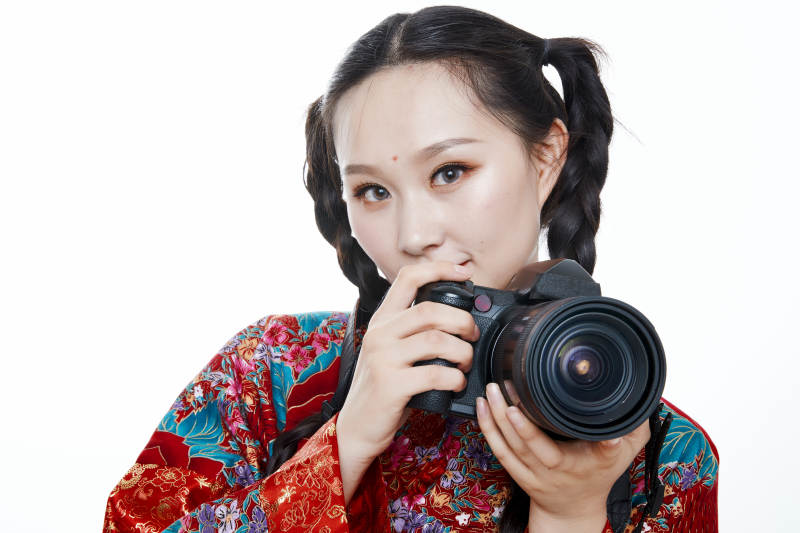 手持相机的亚洲年轻少女的肖像人像图片