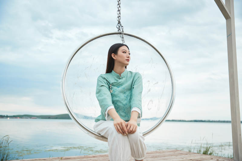 草原湖畔打卡点游玩拍照的亚洲少女图片