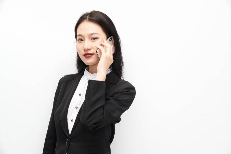身穿西服拿着手机的美丽商务女士图片