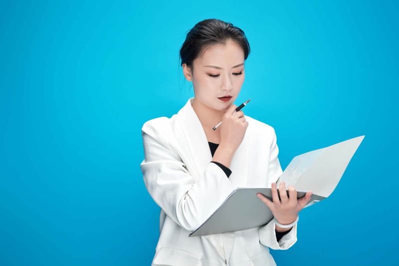 身穿西服拿着手机与文件夹的亚洲商务女士图片