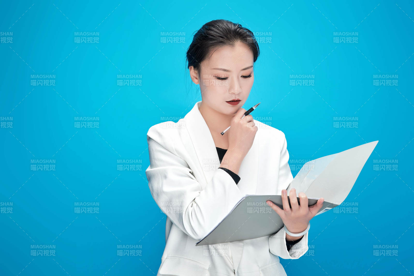 身穿西服拿着手机与文件夹的亚洲商务女士图片