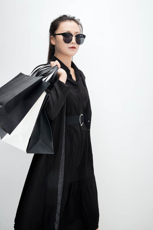 白色背景下手提购物袋时尚美丽的亚洲少女图片