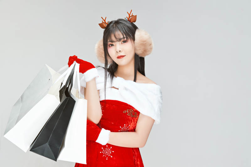 身穿圣诞服饰手提购物袋性感可爱的圣诞女郎图片