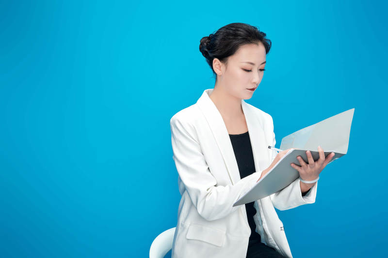 身穿西服拿着手机与文件夹的亚洲商务女士图片