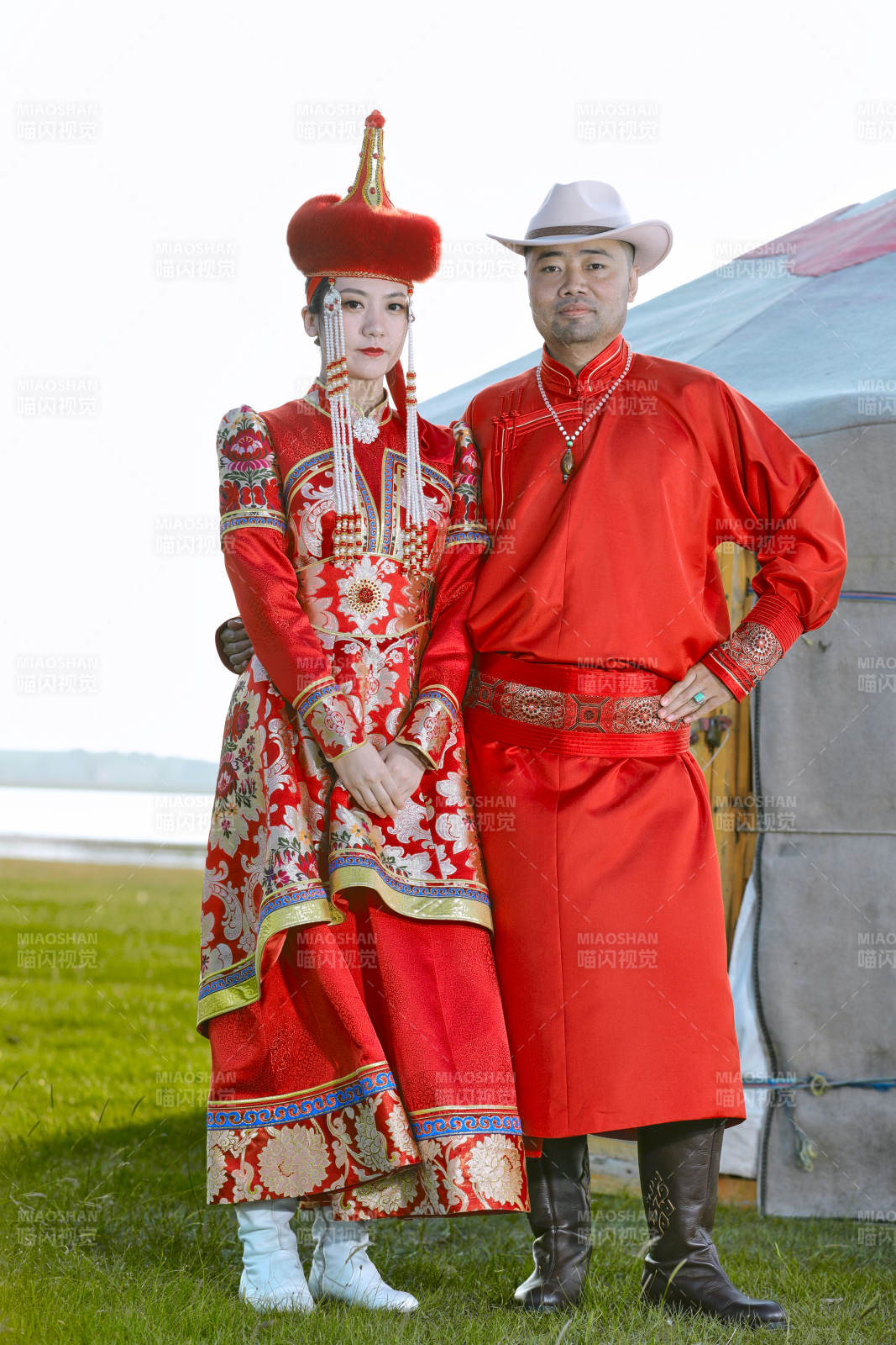 草原上蒙古包前穿蒙古族传统服饰的年轻夫妻图片