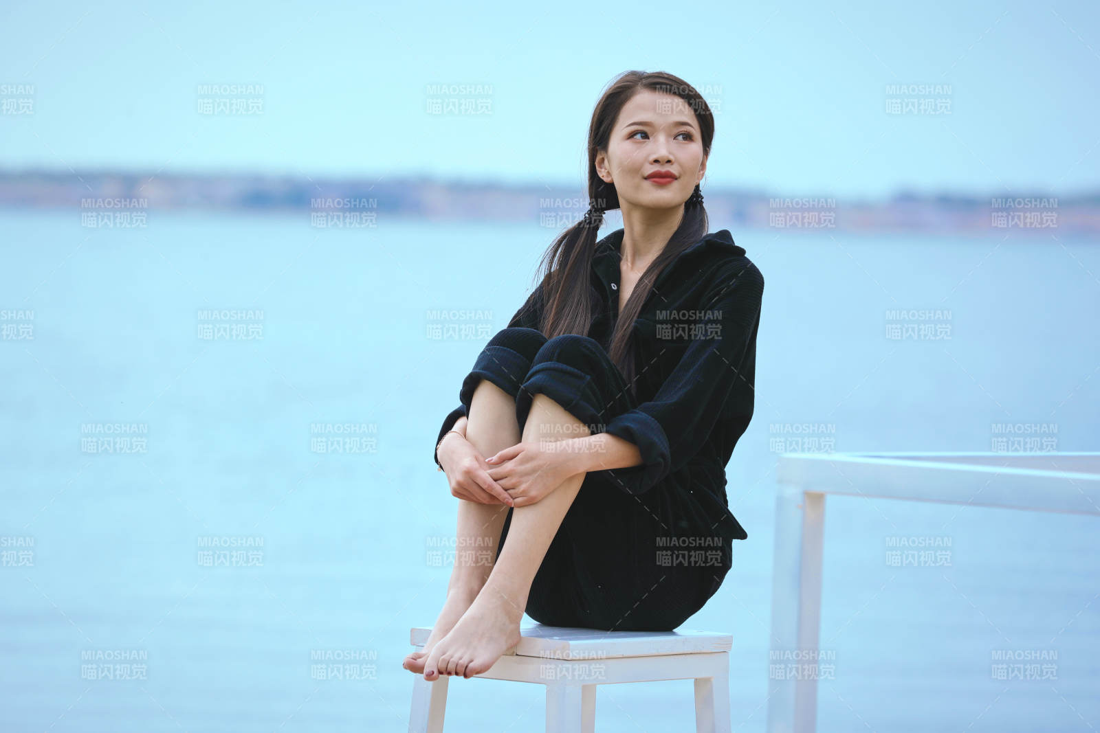 悠闲的坐在美丽湖岸码头的亚洲年轻女性人像图片