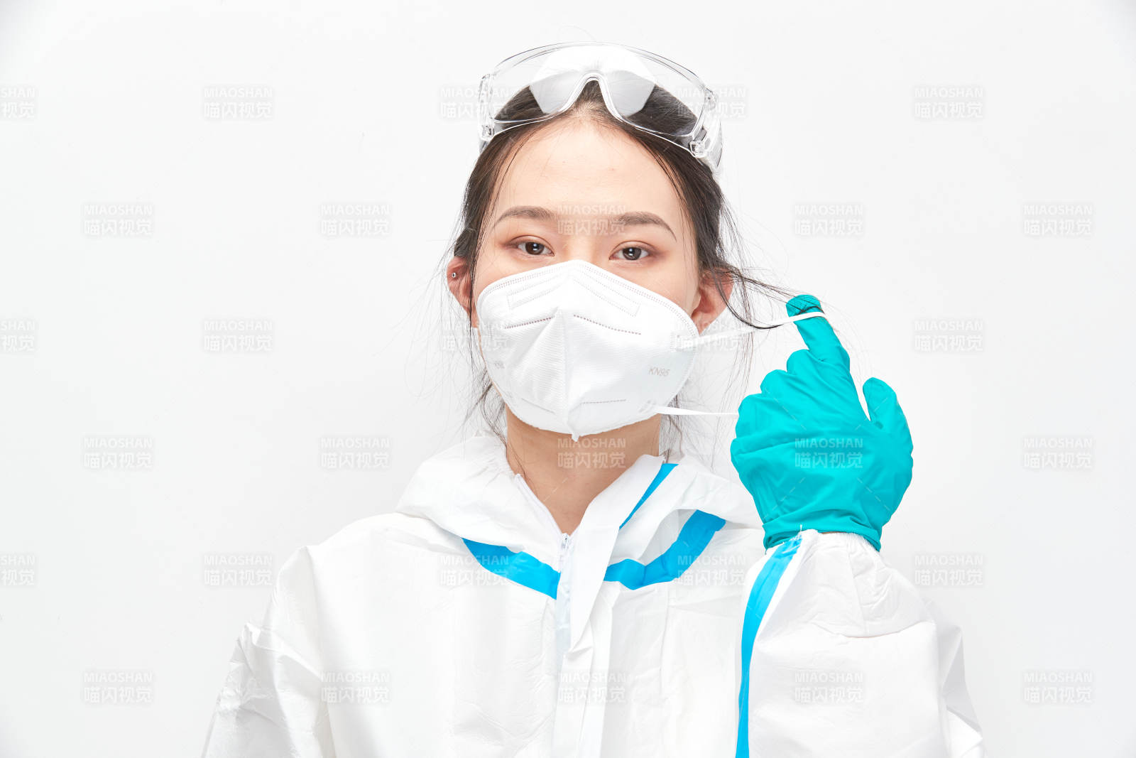 穿白色防护服佩戴护目镜口罩的女性医疗人员图片
