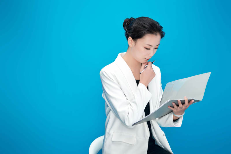 身穿西服拿着手机与文件夹的亚洲商务女士图片