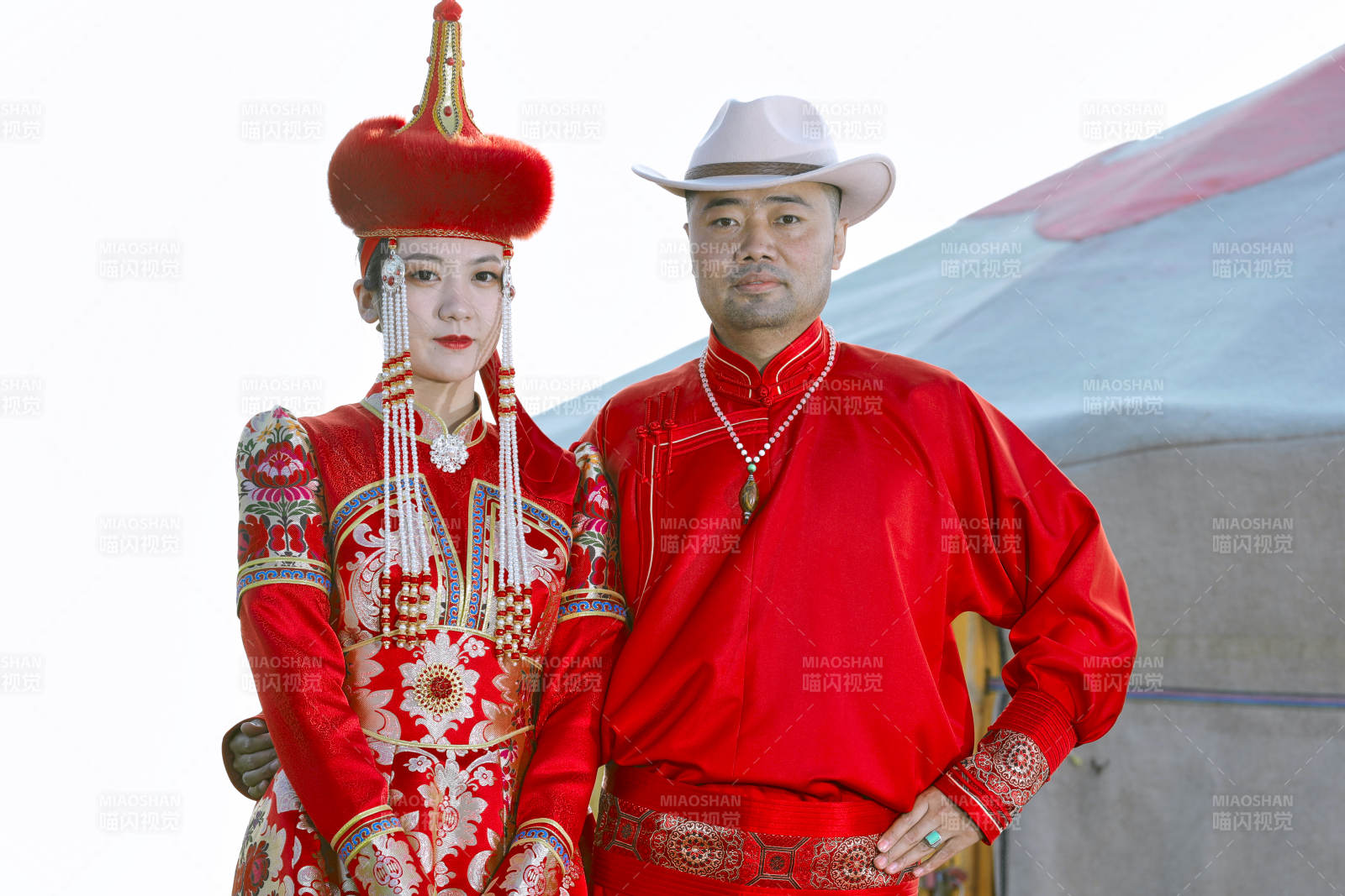 草原上蒙古包前穿蒙古族传统服饰的年轻夫妻图片