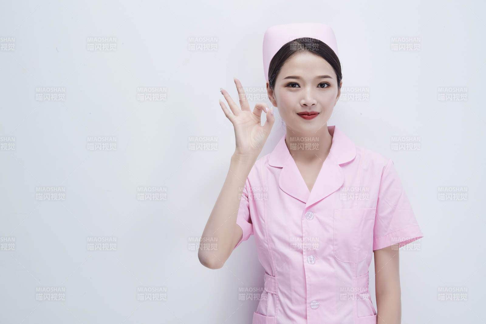 身穿粉色护士服佩戴听诊器的女性医护人员图片