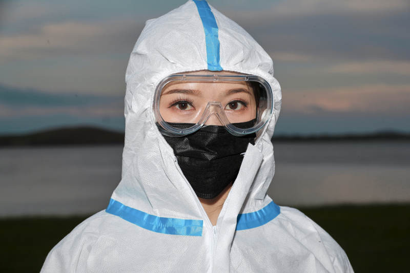 穿白色防护服佩戴护目镜口罩的女性防护人员图片