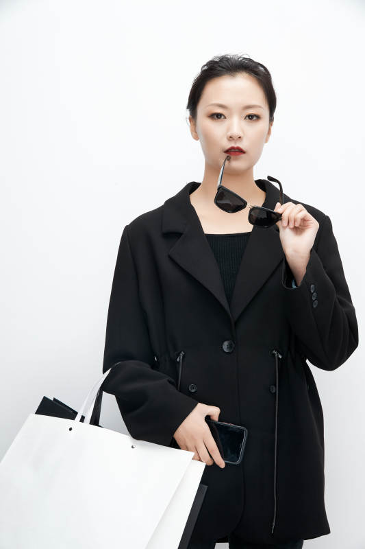 白色背景下手提购物袋时尚美丽的亚洲少女图片