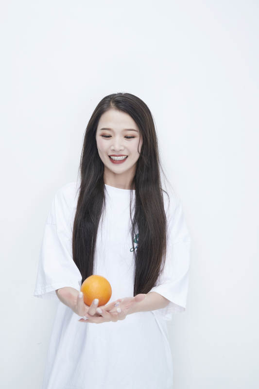 玩耍橙子穿白色长T血的亚洲可爱少女人像图片