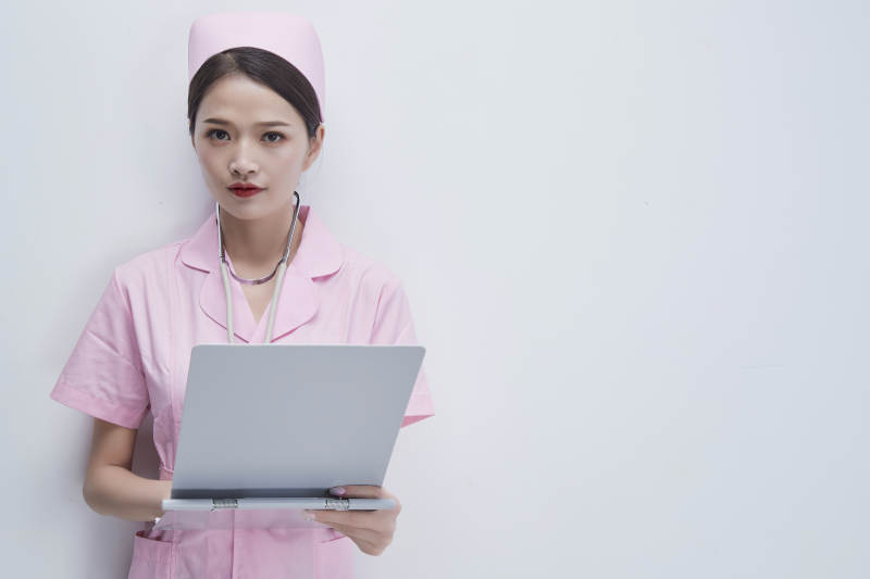 穿粉色护士服戴听诊器手持病历夹的医护人员图片