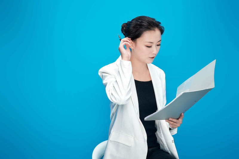 身穿西服拿着手机与文件夹的亚洲商务女士图片