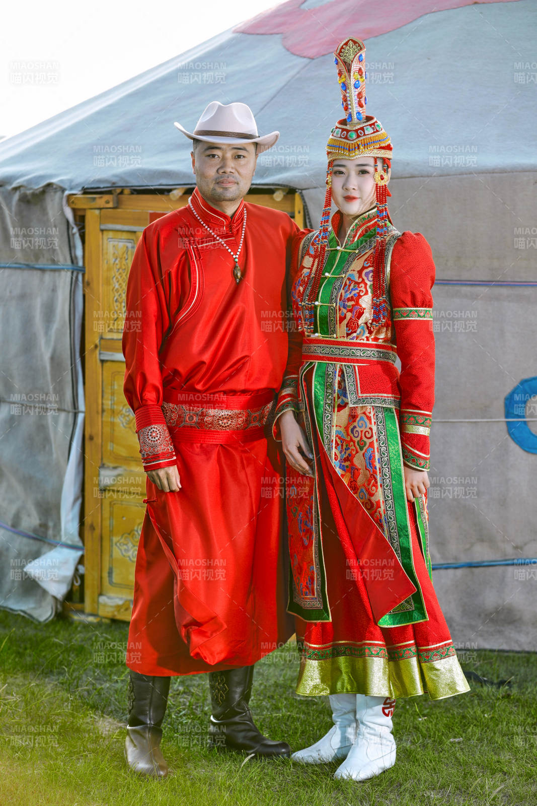 草原上蒙古包前穿蒙古族传统服饰的年轻夫妻图片