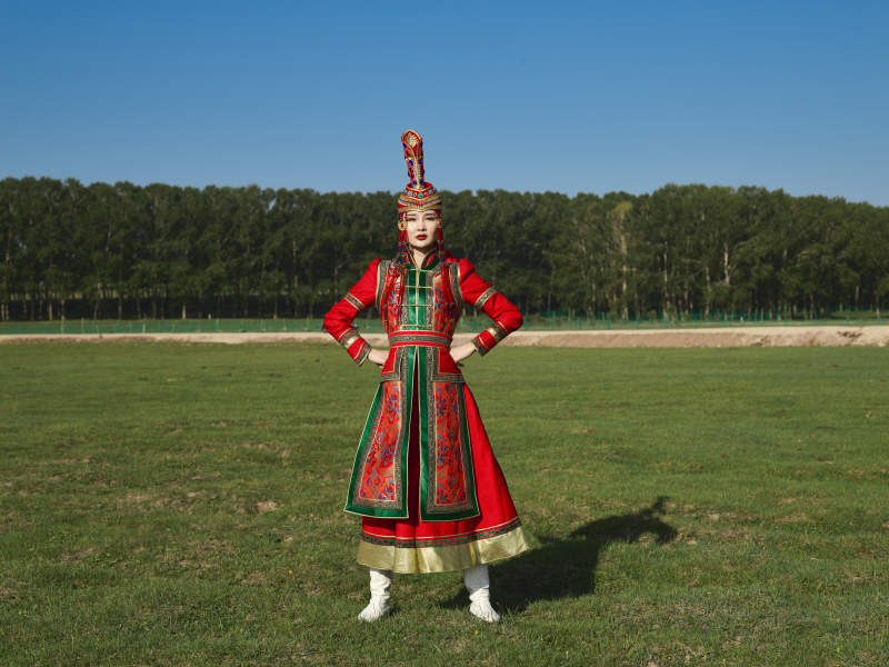 草原上穿着蒙古族传统服饰的亚洲年轻美少女图片