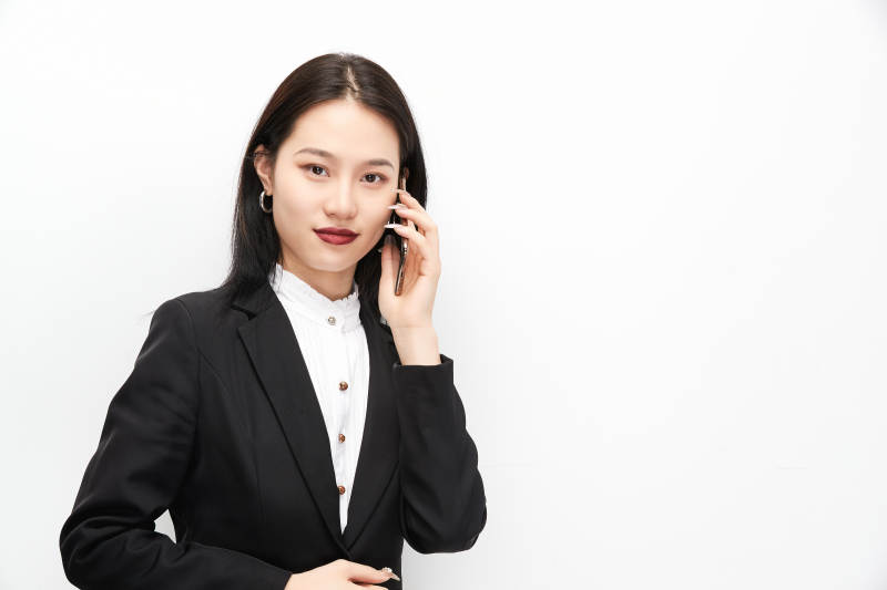 身穿西服拿着手机的美丽商务女士图片
