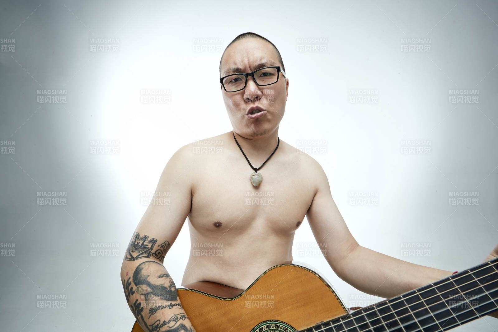 示范演奏古典吉他的亚洲男性乐手人像图片