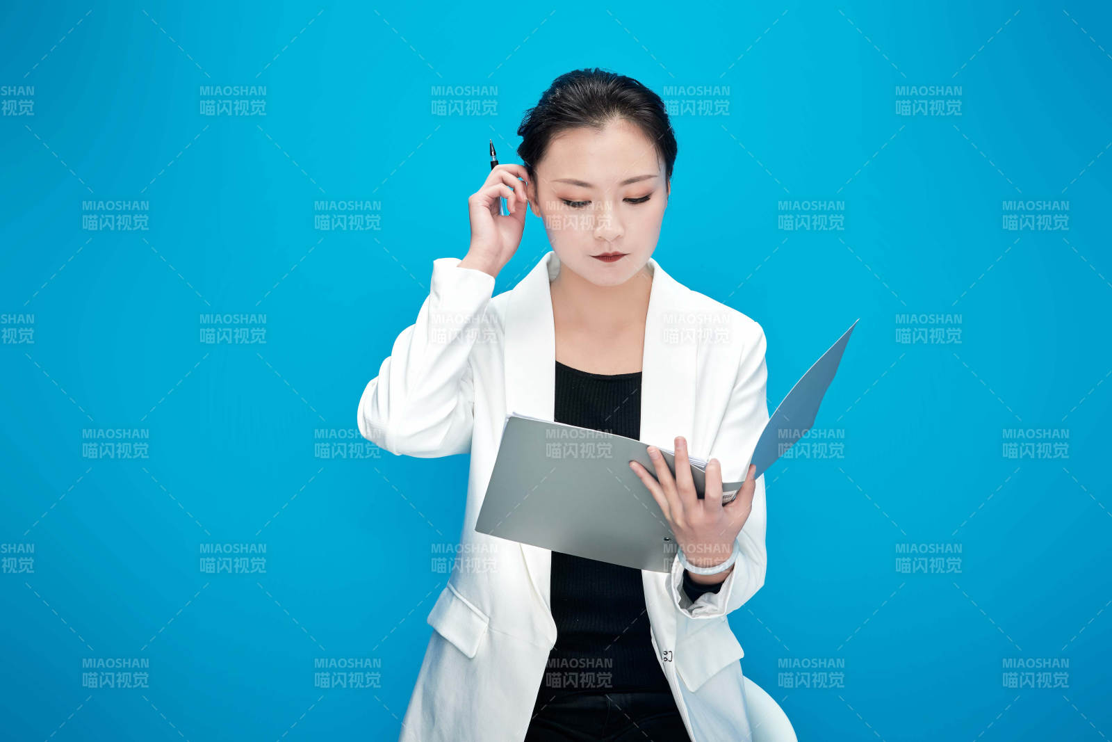 身穿西服拿着手机与文件夹的亚洲商务女士图片