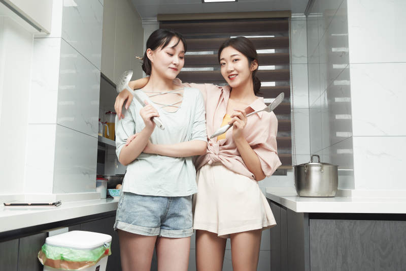 在厨房烹饪美食的亚洲闺蜜少女图片