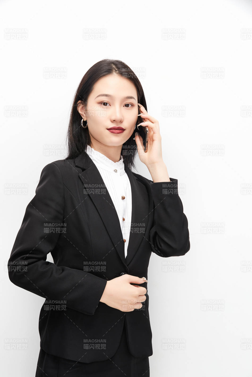 身穿西服拿着手机的美丽商务女士图片