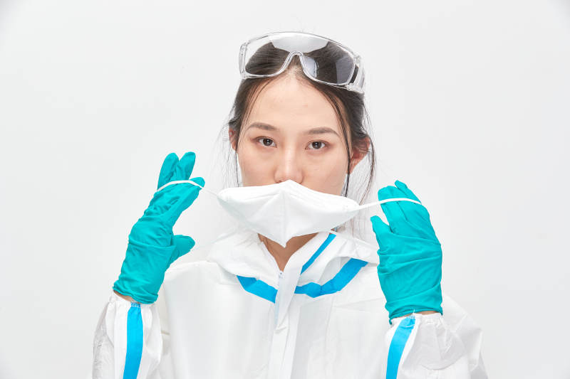 穿白色防护服佩戴护目镜口罩的女性医疗人员图片