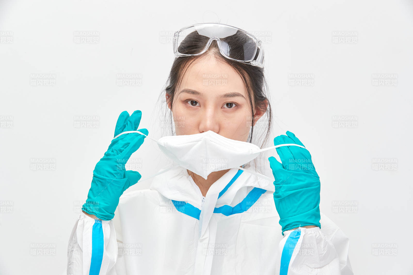 穿白色防护服佩戴护目镜口罩的女性医疗人员图片