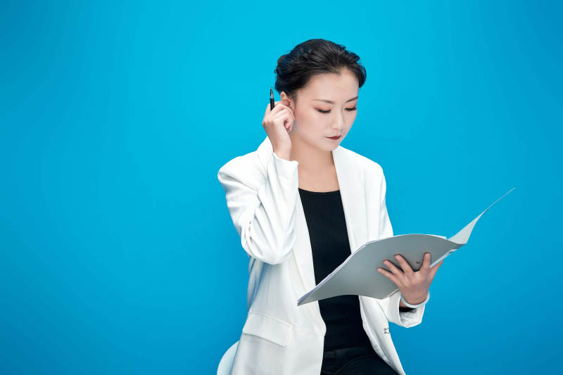 身穿西服拿着手机与文件夹的亚洲商务女士图片