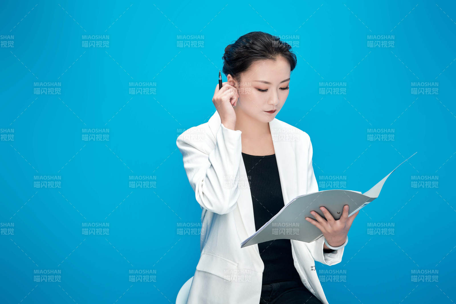 身穿西服拿着手机与文件夹的亚洲商务女士图片