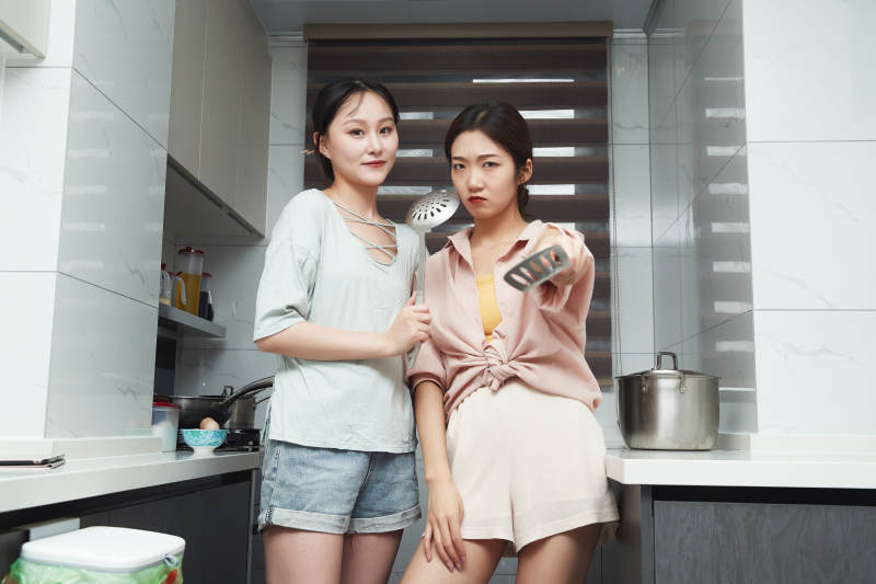 在厨房烹饪美食的亚洲闺蜜少女图片