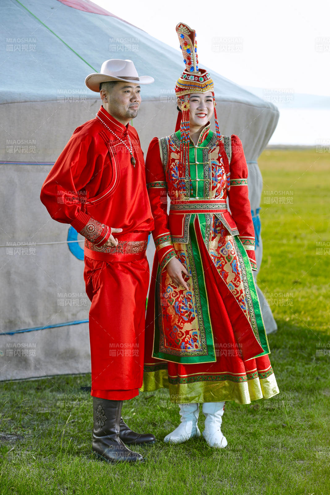 草原上蒙古包前穿蒙古族传统服饰的年轻夫妻图片