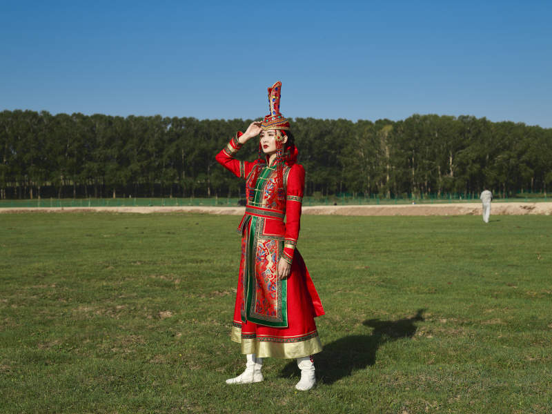 草原上穿着蒙古族传统服饰的亚洲年轻美少女图片