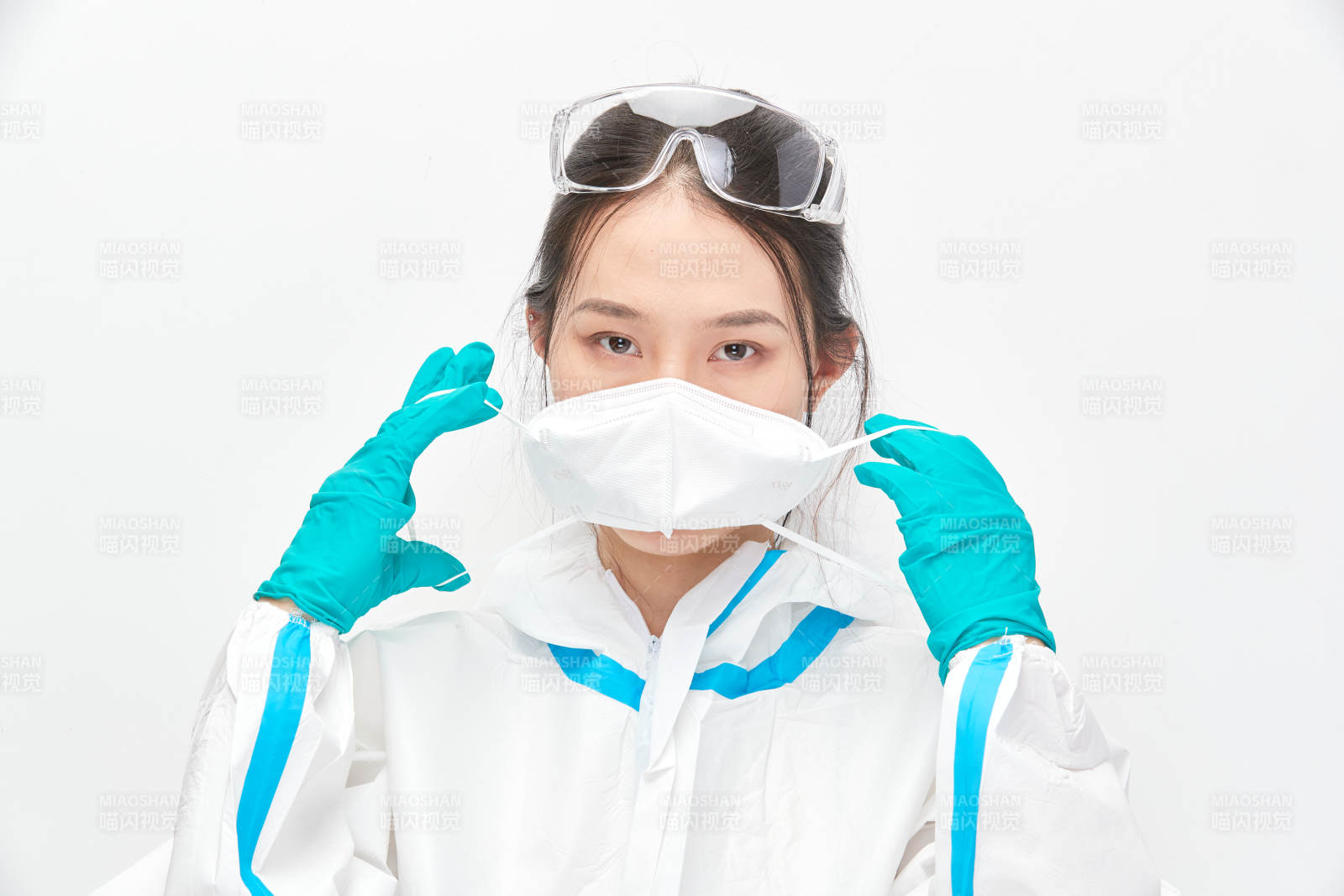 穿白色防护服佩戴护目镜口罩的女性医疗人员图片