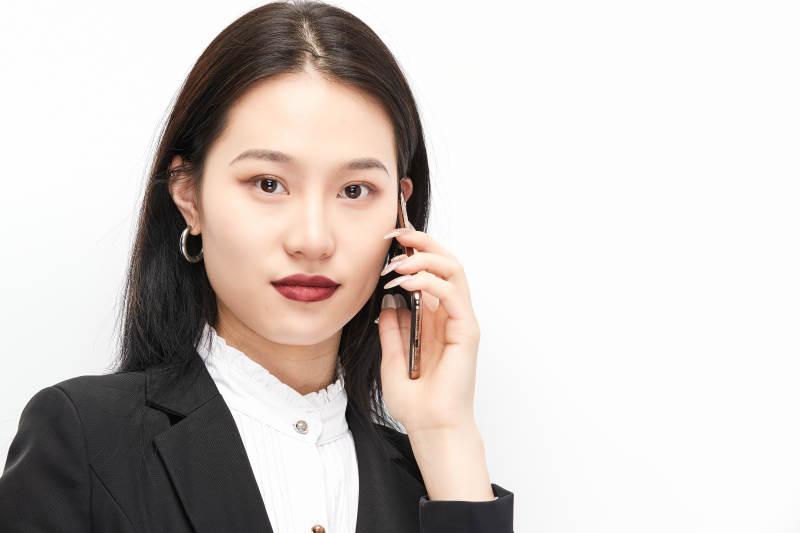身穿西服拿着手机的美丽商务女士图片