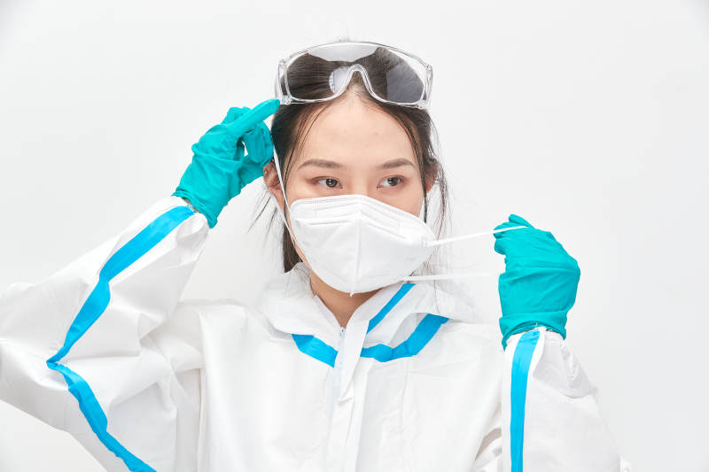 穿白色防护服佩戴护目镜口罩的女性医疗人员图片